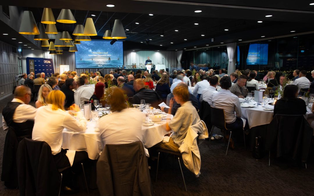 Wide shot of a crowded room at Sandringham Yacht Club during the 2026 ORCV Annual Awards Evening, with Commodore Cyrus Allen speaking at the lectern in the background.