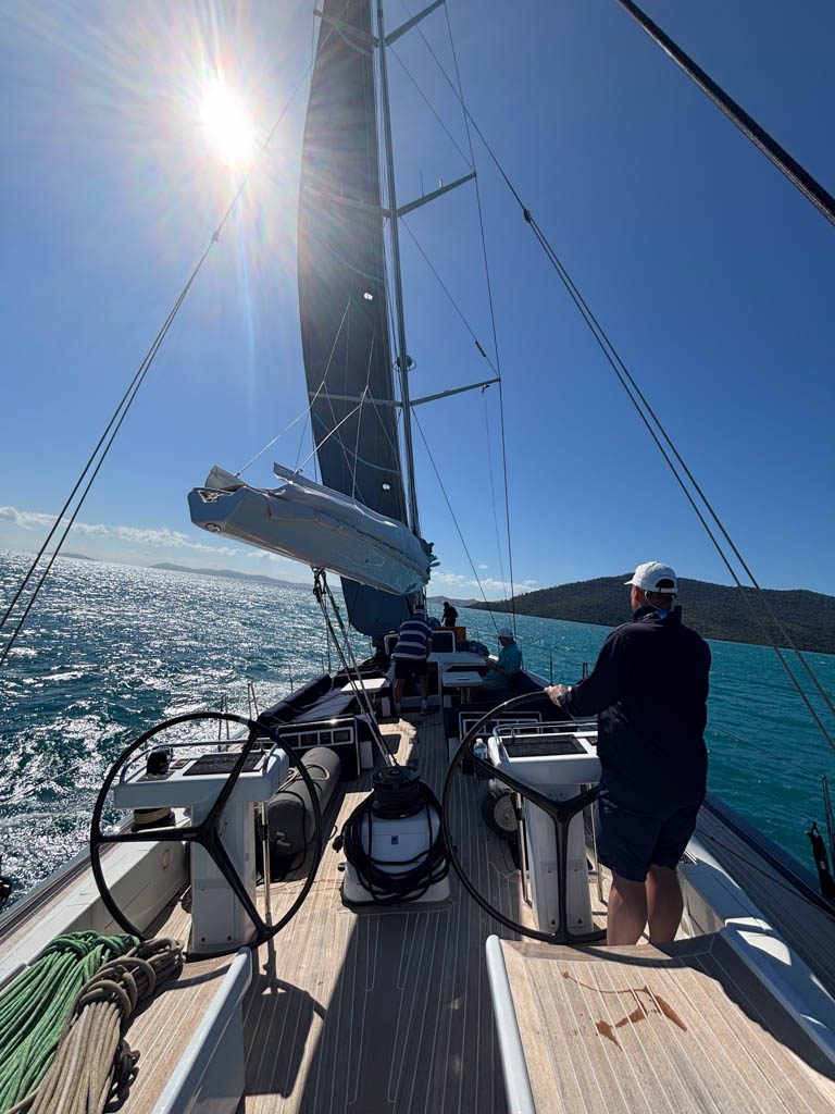 Swan 82 Crackerjack V – Stern View Whitsundays Passage View looking forward from the stern of Swan 82 yacht Crackerjack V sailing through the Whitsunday Islands toward Hamilton Island.