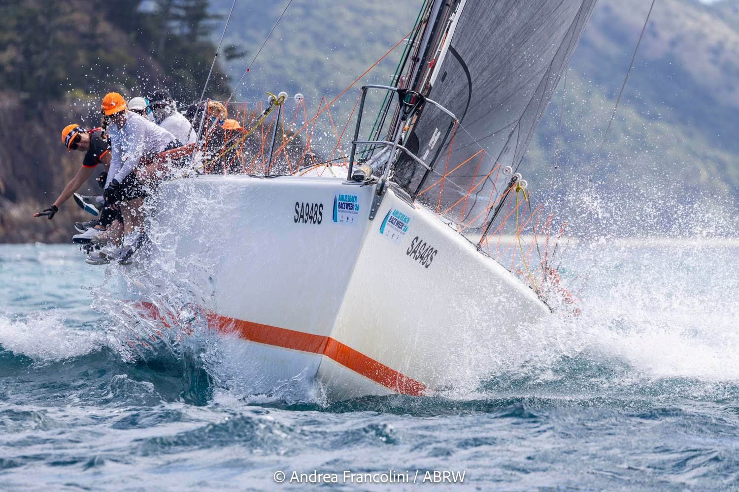 Sydney 38 Clockwork – Offshore Yacht Racing Action Front view of Sydney 38 yacht Clockwork racing toward camera with crew on the rail and bow spray.